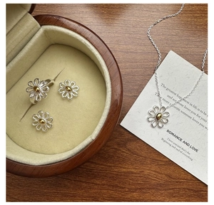Detail of S925 silver daisy jewelry set with gold accents in a premium gift box