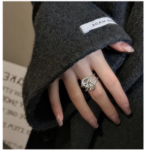 Detailed close-up of S925 sterling silver knotted ring on a finger with polished finish
