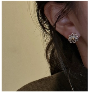 Close-up of S925 sterling silver daisy stud earrings with gold and silver contrast colors