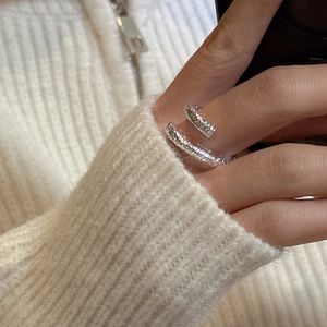 S925 sterling silver crossover ring with hammered texture shown on finger against knitwear