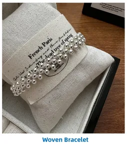 Close-up of S925 sterling silver triple-layer beaded woven bracelet on a display cushion