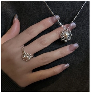 Detailed view of S925 silver daisy pendant and adjustable ring on a model