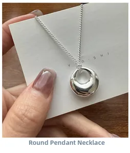Detailed view of s925 sterling silver minimalist circle pendant necklace held on a card