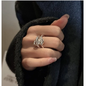 Close-up of a silver knot ring in layered design worn on a finger for a minimalist look