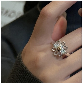 Close-up of S925 sterling silver daisy ring featuring hollow petals and gold center accent