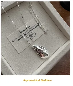 Detailed view of silver irregular lava texture pendant on a long rectangle link chain