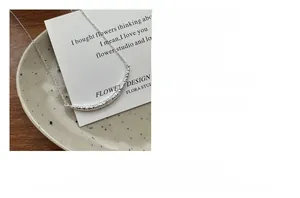 Vue macro du collier Smile en argent 925 avec texture martelée sur assiette en céramique