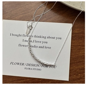 Gros plan du collier sourire en argent S925 montrant le poinçon et la texture de lave