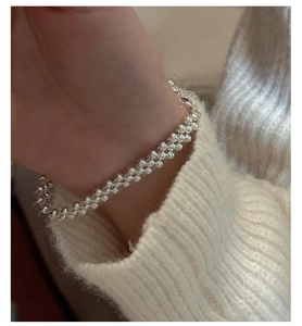 Macro shot of S925 sterling silver three-layer beaded woven bracelet on model wrist