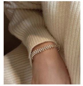 Macro detail of a 925 sterling silver woven beaded ring on a cozy sweater background