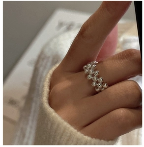 Close-up of a 925 sterling silver double-row beaded band ring on a hand with soft lighting