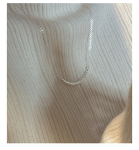 Gros plan d'un collier sourire en argent 925 avec texture sur fond de tissu en maille