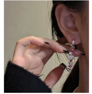 Detail of silver drop earrings with clear heart crystal and red beads on model
