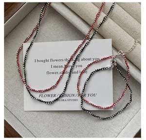 Vue détaillée d'un ensemble de bijoux en cordon tressé rouge et noir avec perles d'argent