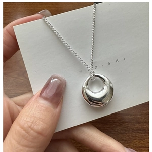 Macro shot of minimalist silver hollow round pendant necklace with high polish finish