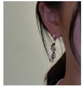 Detailed shot of S925 silver beaded earrings with clear crystals and red accents on ear