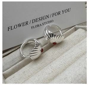 Macro detail of S925 sterling silver hoop earrings with red agate and radial stripe pattern