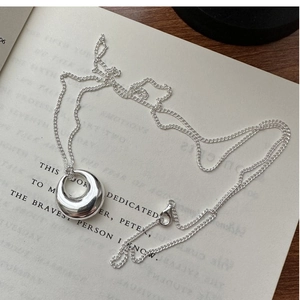Macro shot of 925 sterling silver ring pendant on a book with mirror finish detail