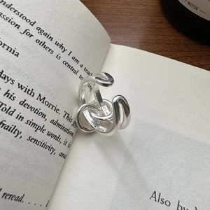 S925 sterling silver multi-layer knotted ring displayed on an open vintage book