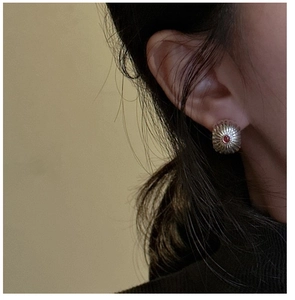 Detail of S925 silver earring with red agate stone and vintage radial pattern on model