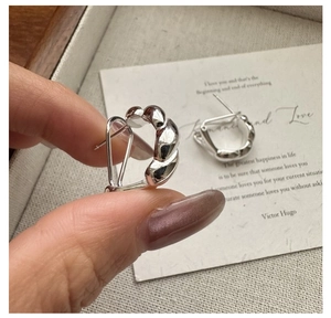 Nahaufnahme der S925 Sterling Silber Croissant-Ohrringe mit gedrehter Textur und Glanzfinish