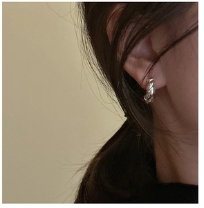 Nahaufnahme von S925 Sterling Silber gedrehten Creolen, getragen von einem Modell für einen Look