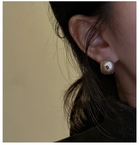 Detail of S925 silver stud earring with red agate stone and radial sunburst texture