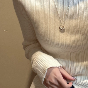Minimalist 925 sterling silver circle pendant necklace worn on a beige sweater