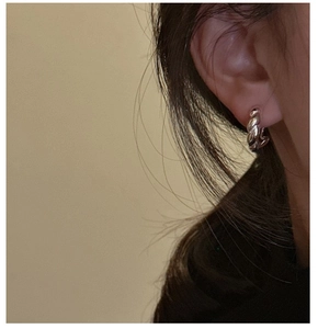 Nahaufnahme der S925 Sterling Silber Creolen mit gedrehtem Seildesign am Modellohr