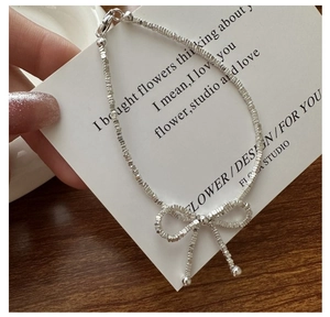 Close-up of S925 sterling silver bowknot bracelet with textured silver beads