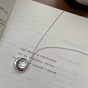 925 sterling silver necklace with irregular lava-style pendant on an open book