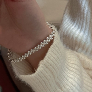 Three-layer S925 sterling silver beaded bracelet styled on a model's wrist with knitwear