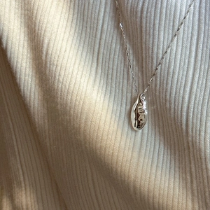 S925 sterling silver organic molten pendant necklace on ribbed knit fabric texture