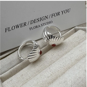 Detailed close-up of S925 sterling silver shell earrings with red agate insets
