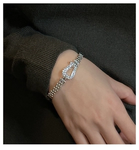 Detailed close-up of S925 silver horseshoe buckle and braided mesh link bracelet