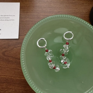 S925 sterling silver hoop earrings with clear crystal beads and red accents on glass plate