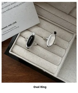 Close-up of S925 silver oval rings with chalcedony and agate on beige jewelry display