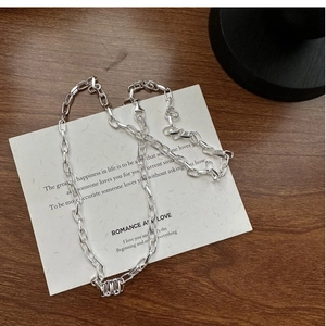 Détail du collier en argent S925 avec pendentif texturé sur une carte blanche