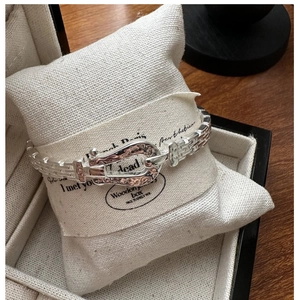Close-up of S925 silver cuff bracelet with horseshoe buckle on a jewelry pillow