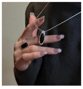 Detail showing an S925 sterling silver ring and pendant set with black agate stones