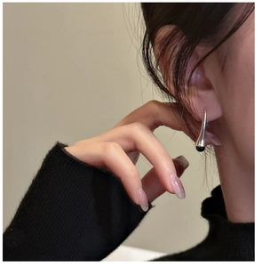 Detail of S925 sterling silver hook earring with elegant black bead on a female model