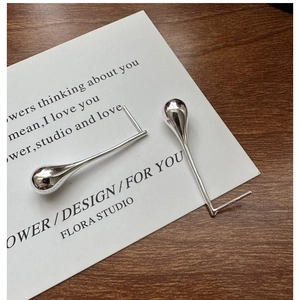 Macro shot of minimalist S925 sterling silver water drop earrings on display card
