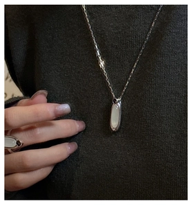 Dettaglio della collana e anello in argento S925 con agate bianche ovali su maglia scura