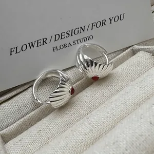 S925 sterling silver shell earrings with red agate insets on beige linen box