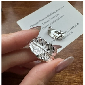 Macro shot of S925 sterling silver leaf earrings showing detailed plant vein textures
