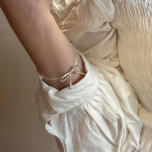 S925 sterling silver bow bracelet with sparkling crushed silver texture on model wrist