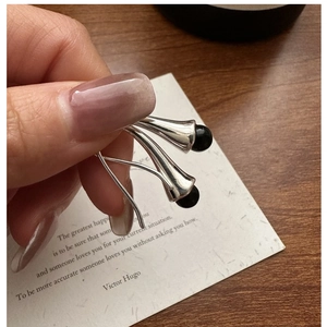 Detail of S925 silver curved hook earring with elegant round black onyx bead inlay