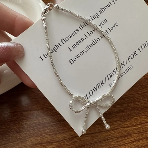 S925 sterling silver beaded necklace with a bow pendant on an aesthetic gift card