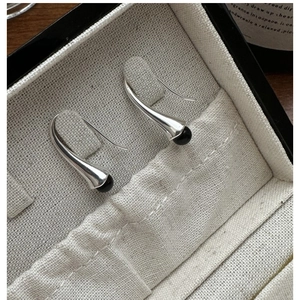 Detail of silver drop earrings with black beads presented in a premium jewelry gift box