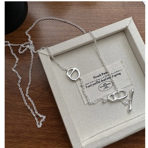 Dettaglio macro della collana in argento S925 con chiusura a barra su sfondo di legno